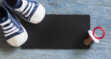 Üstten görünüm şirin bebek ayakkabı ve metniniz için ahşap arka plan siyah kurulu