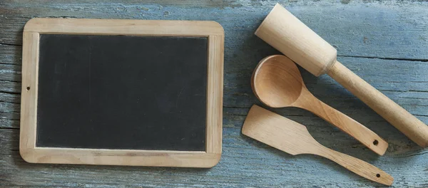 Overhead view of wood utensils with blackboard on rustic wood table, Top view of wood kitchenware