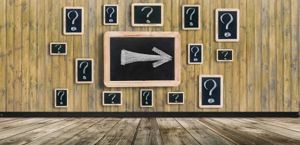 Question marks - white chalk drawing on small blackboard hanging old wooden wall
