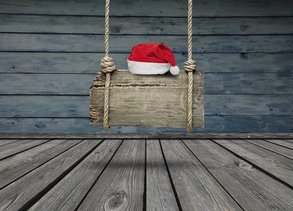 老木横幅挂在一个黑暗的蹩脚房间和复制空间的圣诞老人帽子 — 图库照片