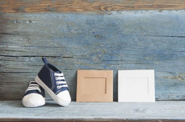 Bir ahşap boş fotoğraf çerçevesi için kopya alanı ile sevimli minik bebek ayakkabıları