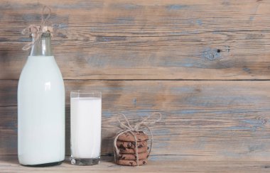 Bardak süt ve çikolata parçalı kurabiye ahşap arka plan üzerinde