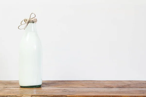 瓶新鲜的牛奶和木制的桌子上的玻璃 — 图库照片