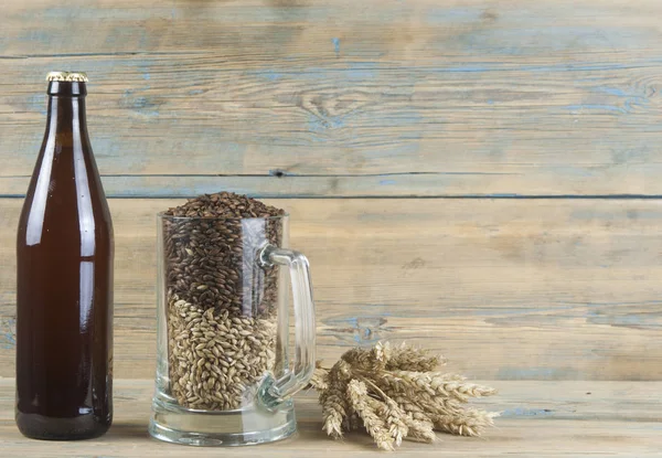 玻璃和瓶啤酒用小麦在木板上的耳朵 — 图库照片