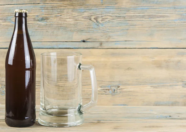 ボトルと木製の背景に空のビール グラス — ストック写真