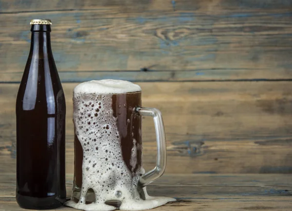 bottle and glass with beer on wood table