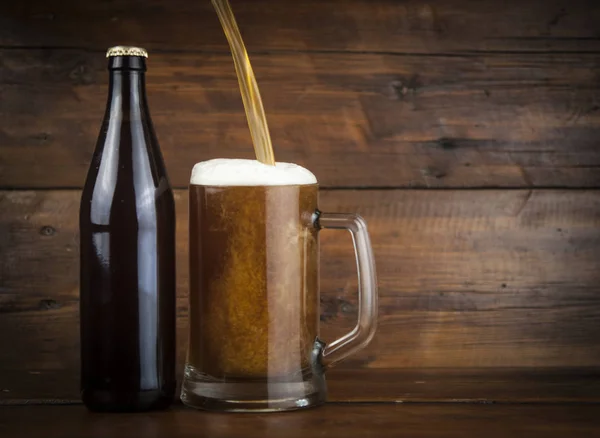 ボトルとガラス木製テーブルの上のビール — ストック写真