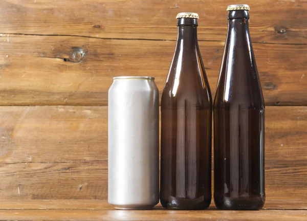 空白の金属缶と木製の背景にビール瓶 — ストック写真