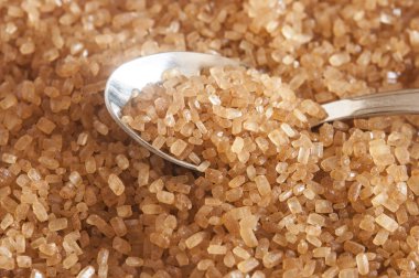 Paslanmaz Çelik kaşık ve toz şeker sarı arka plan üzerinde şeker kamışı şeker, şeker ve kaşık