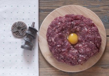yuvarlak ahşap kesme tahtası üzerinde yumurta sarısı ile çiğ kıyma