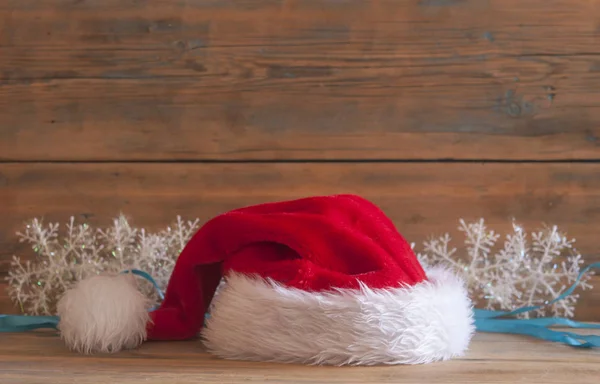 在木桌上的圣诞节装饰圣诞老人帽子 — 图库照片