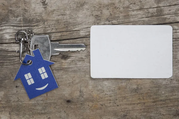 木制背景上的银钥匙和空白名片 房地产概念 — 图库照片