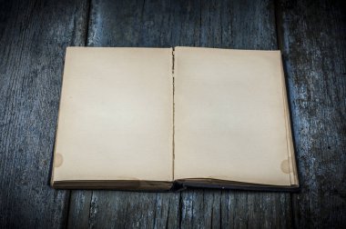 Eski kitap ile boş çarşafları ve ahşap arka plan üzerinde