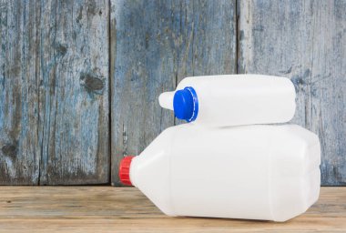 ahşap arka plan üzerinde farklı yapılandırma plastik galon çifti