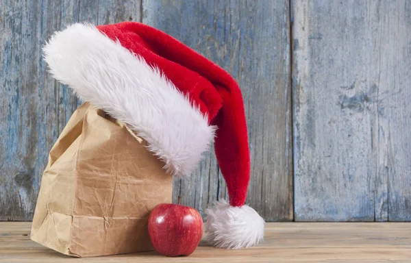 Красное Яблоко Шляпа Санта Клауса Деревянном Фоне Стола — стоковое фото
