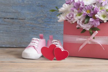 Küçük çocuk ayakkabı ve ahşap masa arka plan üzerinde güzel çiçek buketi