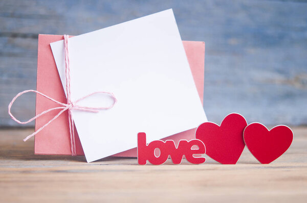 День святого Валентина концепция: слово любовь красными буквами и два сердца на деревянном столе
