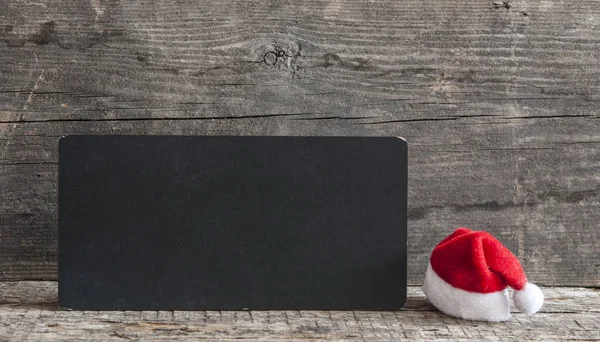 Braune Weihnachtstafel Mit Kopierplatz Freitext Als Grußkarte Weihnachtsdekoration Mit Weihnachtsmütze — Stockfoto