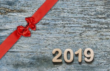 Dekoratif kırmızı kurdele ve ahşap arka plan üzerinde yay