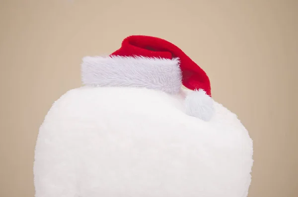 クリスマスの背景 黄色の背景に雪のヒープのサンタ帽子 — ストック写真