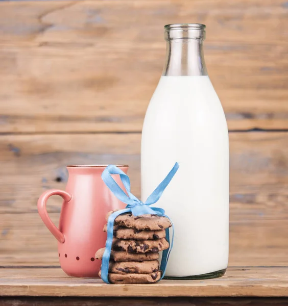 一叠饼干 一瓶牛奶 木制背景上的粉红色杯子 乡村早餐 — 图库照片