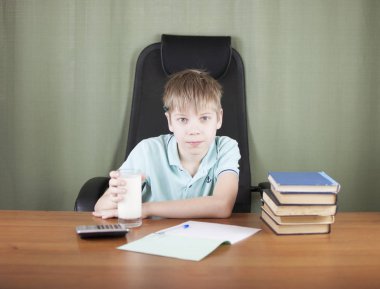 Birçok kitap ve kırmızı elma ile masada oturan akıllı okul çocuğu. Eğitim kavramı. 
