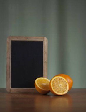 Grunge arka plan üzerinde ahşap masa üzerinde boş yazı tahtası ile taze portakal suyu