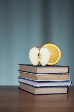 Kitaplar ve ahşap masa üstünde Kırmızı elma yığını 