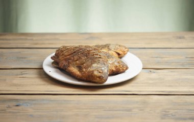 Kızarmış balık - havuz beyaz bir plaka üzerinde ahşap masa yakın