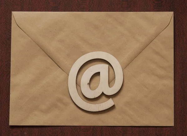 sign e-mail, paper letters on a wooden background table. Internet, correspondence.