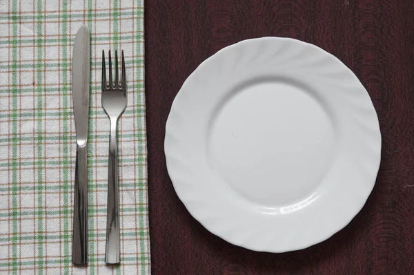 Placa Blanca Limpia Blanco Con Tenedor Cuchillo Sobre Una Servilleta —  Fotos de Stock