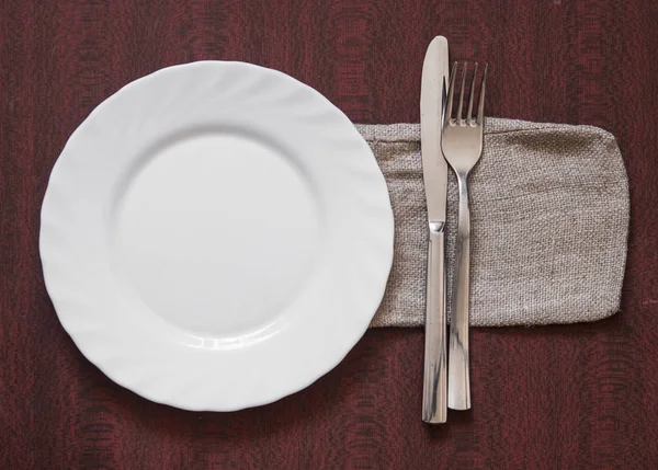 カラフルなナプキン木製の背景の上にナイフとフォークの空白のきれいな白いプレート 食品への招待 提供新鮮な食事を調理する準備ができました テキスト 記号を使用するための良い — ストック写真