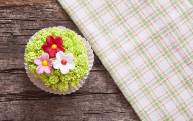 Çiçekler bahar ahşap arka plan için süslenmiş cupcakes