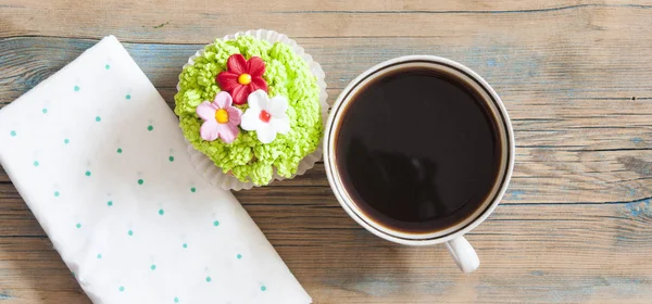 लाकडी टेबलवर गरम कॉफी कप फ्लॉवर वसंत ऋतु कपकेक — स्टॉक फोटो, इमेज