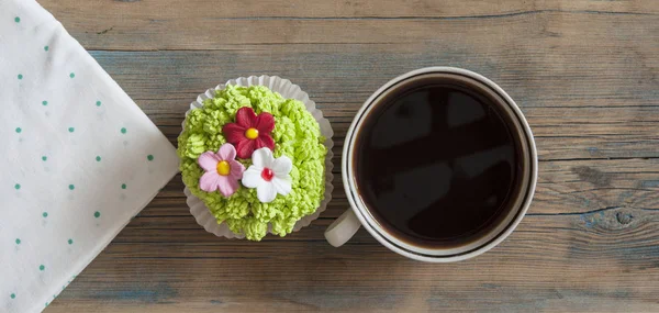 Blumenfrühlingskuchen mit heißer Kaffeetasse auf Holztisch — Stockfoto