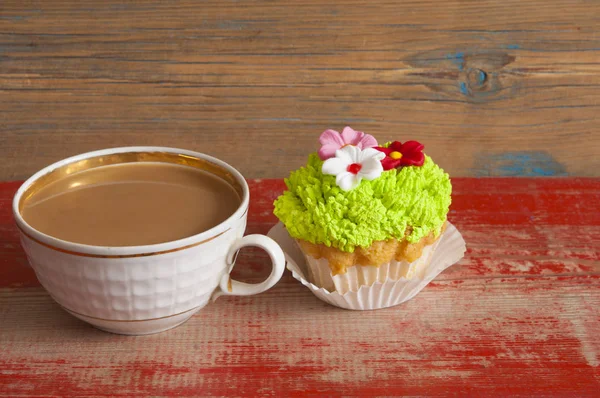 Flor primavera cupcake con taza de café caliente en mesa de madera —  Fotos de Stock