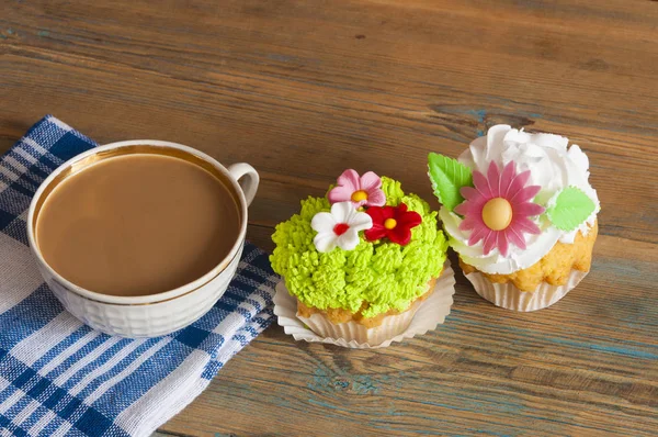 Bloem lente cupcake met warme koffie cup op houten tafel — Stockfoto