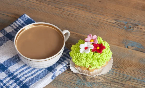 Blumenfrühlingskuchen mit heißer Kaffeetasse auf Holztisch — Stockfoto