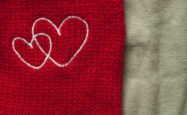 Beyaz kalpler kırmızı bir tuval üzerinde bir haç ile el yapımı işlemeli
