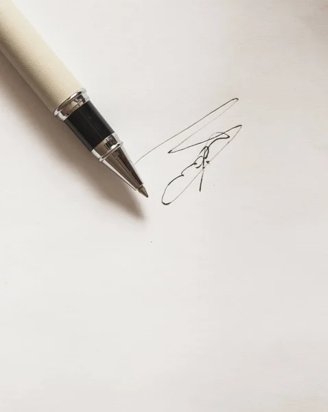 Pen met handtekening en document in achtergrond — Stockfoto