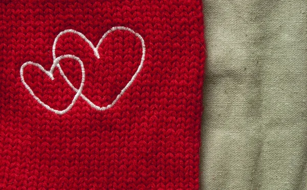 White hearts embroidered handmade with a cross on a red canvas — Stock Photo, Image