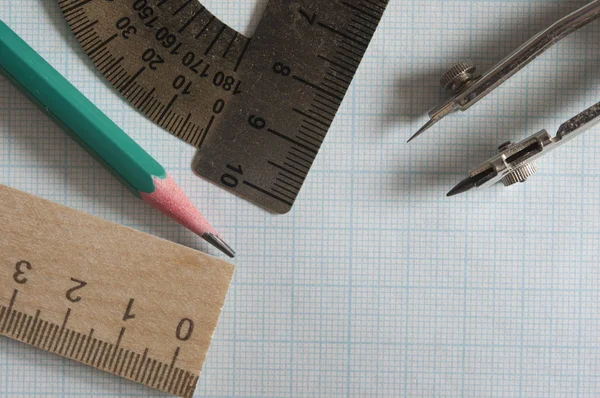 Set of drawing instrument and rulers on graph paper — Stock Photo, Image