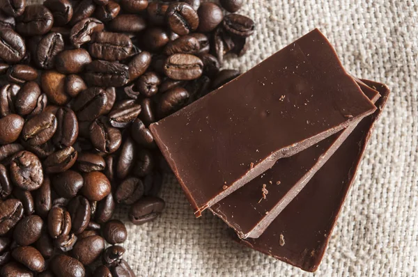 Chocolade en koffiebonen op een textiel achtergrond — Stockfoto