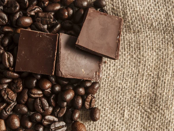 Csokoládé-és kávébab textilháttérrel — Stock Fotó