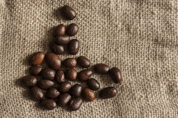 Kávová zrna na drsné pytloviny — Stock fotografie