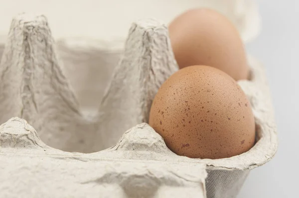 Braune Hühnereier in einem grauen Karton — Stockfoto