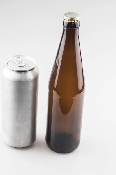 Scatola di alluminio vuota e bottiglia di birra marrone su sfondo bianco. Mo — Foto Stock