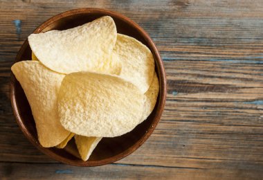 Ahşap kase gevrek patates cipsi. Tuzlu patates cipsi. 