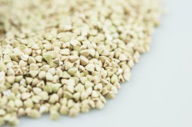 Beyaz arka planda ham yeşil karabuğday yığını. Vegan veya vegetaria