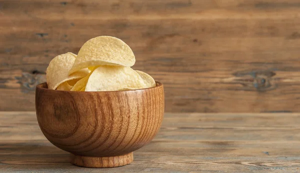 Crispy potato chips in wooden bowl. Salted potato chips. — Stock Photo, Image